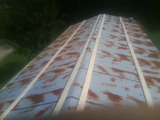 Rusted metal roof panels with new wood purlins before replacement — Storm Damage Roof Repair in Sound Beach by Roofing Brothers
