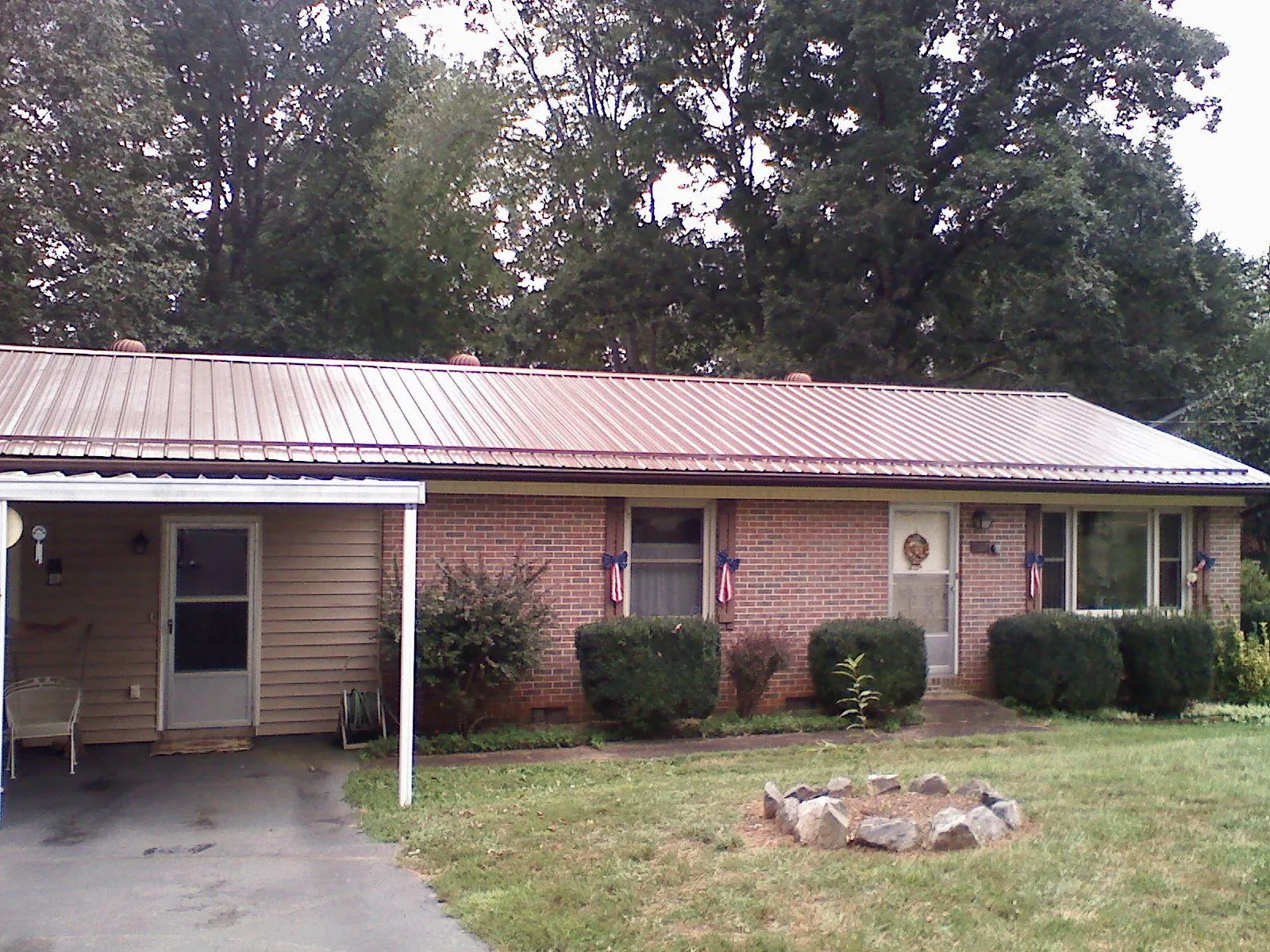 Bronze metal roof and carport on a brick ranch home — Roof Repair work by our crew in Sound Beach